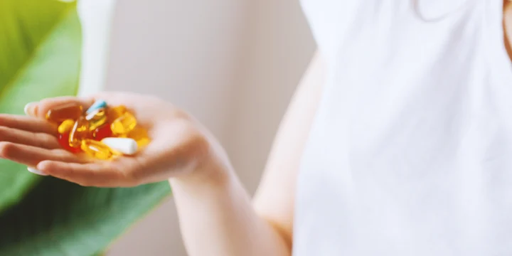 A woman holding keto pills on her hand for ketosis